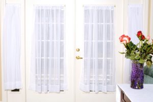 White French doors with sheer curtains and gold handles highlighting French door security.