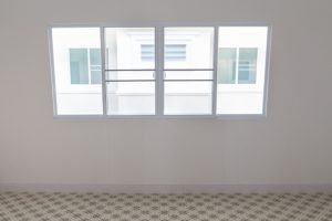 Interior view of a room featuring a double-glazed sliding window with a clear view of an adjacent building, highlighting the efficiency and modern design of double-glazed sliding windows. 