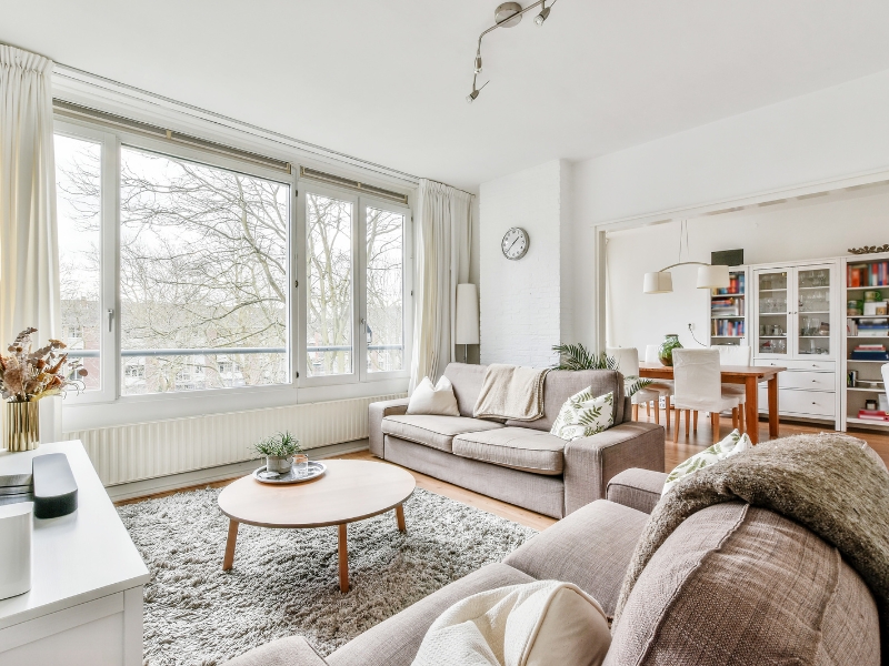 Bright living room with modern decor and large uPVC casement window styles, showcasing natural light and cosy furniture arrangement.