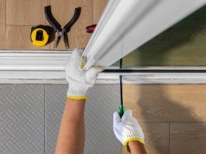 Worker installing slide in doors with tools, highlighting the installation process for precise fitting.