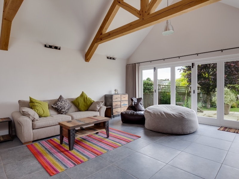 Spacious living room installing bifold doors with exposed beams and modern decor.