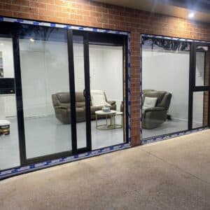 Modern uPVC Sliding Doors with black frames opening to a lounge with sofas and coffee table.